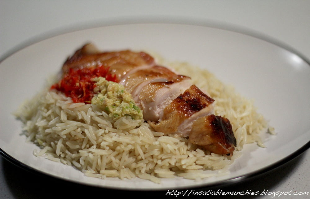 Fragrant chicken rice is topped with roast chicken and local condiments