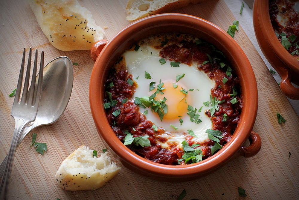 A middle eastern version of eggs and baked beans, shakshuka features a tomato-based capsicum and bean stew, served with an egg baked right into it.