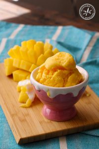 This simple two ingredient recipe makes a thick and creamy frozen yoghurt, in no time at all. Here it's served in an ice cream bowl, with fresh mango on the side.