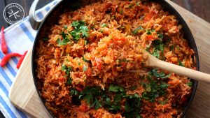 Rice, flavoured with capsicum, chilli and tomato, is cooked in a deep pan till it's fragrant and tender.