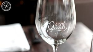A customised wine glass with the name of the restaurant printed on the side.