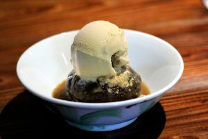 Sticky Date Pudding sits in a pool of caramel and is topped with house made salted caramel ice cream