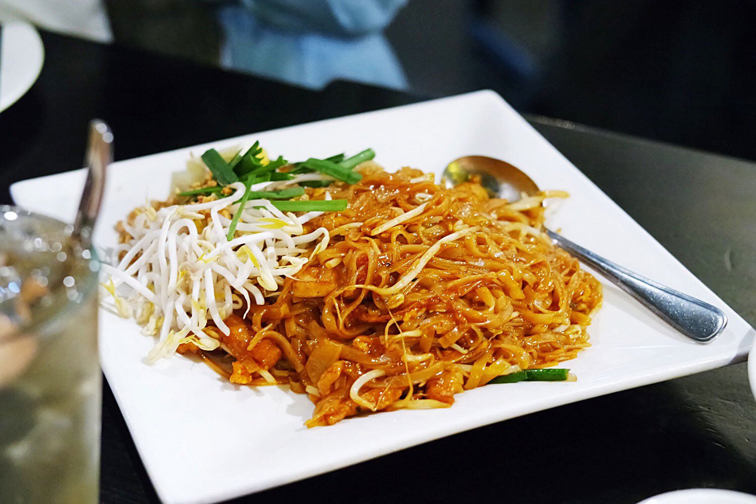 Rice stick noodles are stir fried with radish, sauce and chicken. Served with a side of chopped peanuts and fresh bean sprouts.