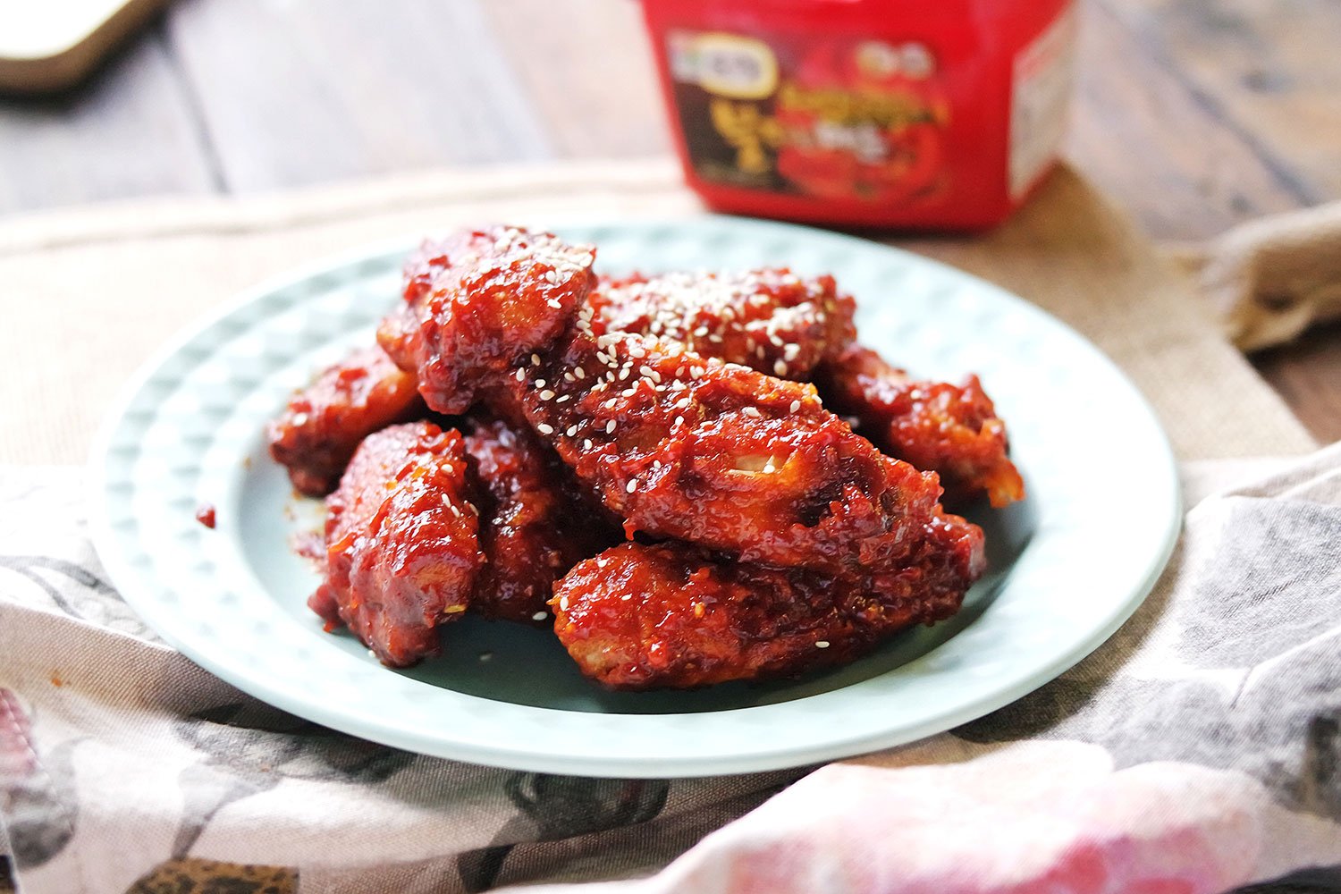 Crispy fried chicken is covered in a korean chilli paste glaze and garnished with sesame seeds