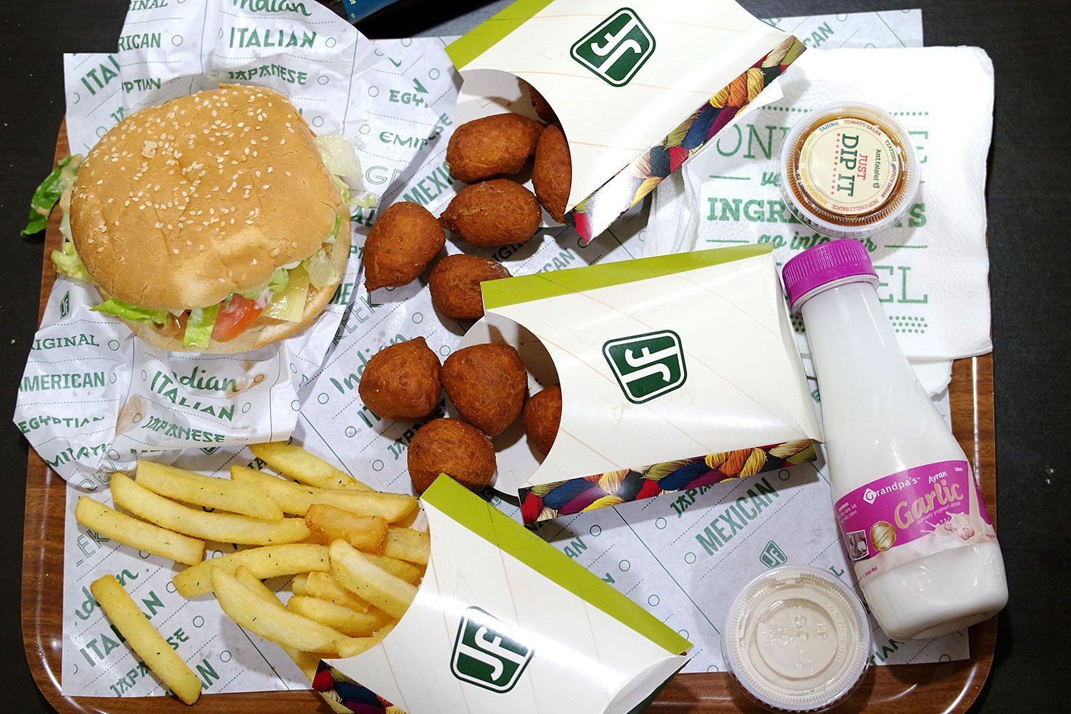 Clockwise from top left: American Sandwich, spinach and feta poppers, salsa dip, garlic yoghurt drink, fries and jalapeño cheese poppers in the centre.