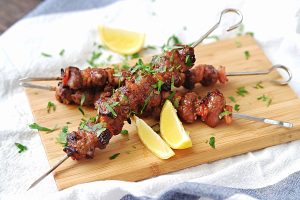 Marinated chicken hearts are alternately skewered with bacon pieces, then grilled and basted with the marinade.