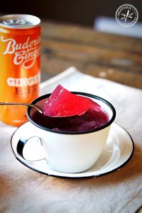 Sparkling ginger beer and berry jelly, served in an enamel teacup.
