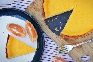 Aerial shot of grapefruit tart with a slice cut out on a plate