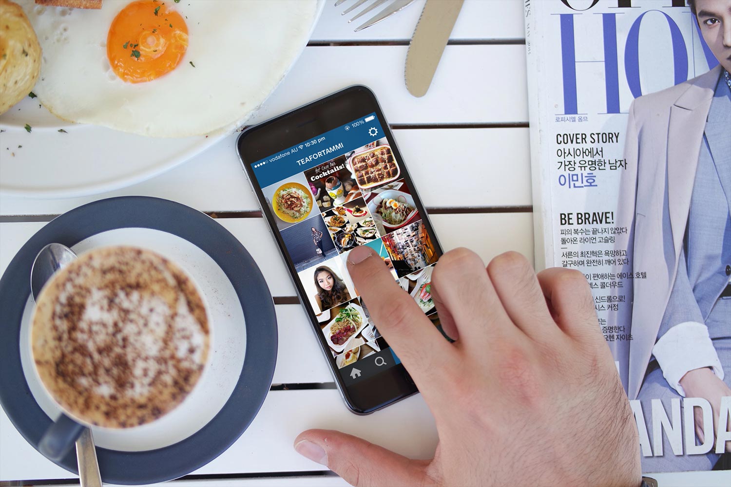 a phone on the table with the instagram screen up, surrounded by coffee and breakfast